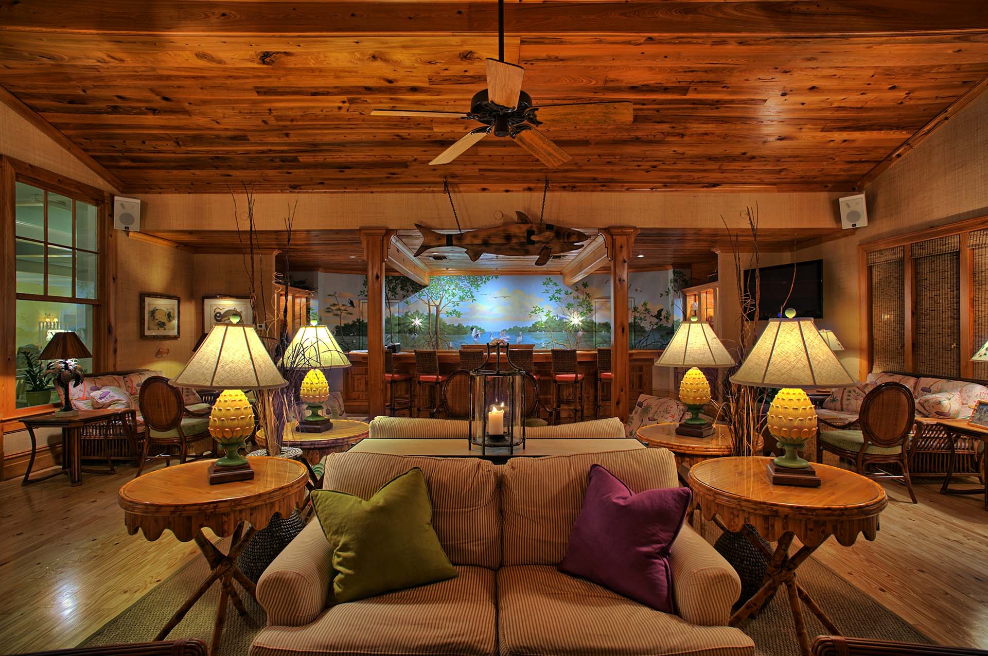 Comfy seating flanked by quartet of yellow pineapple lamps and a paneled ceiling