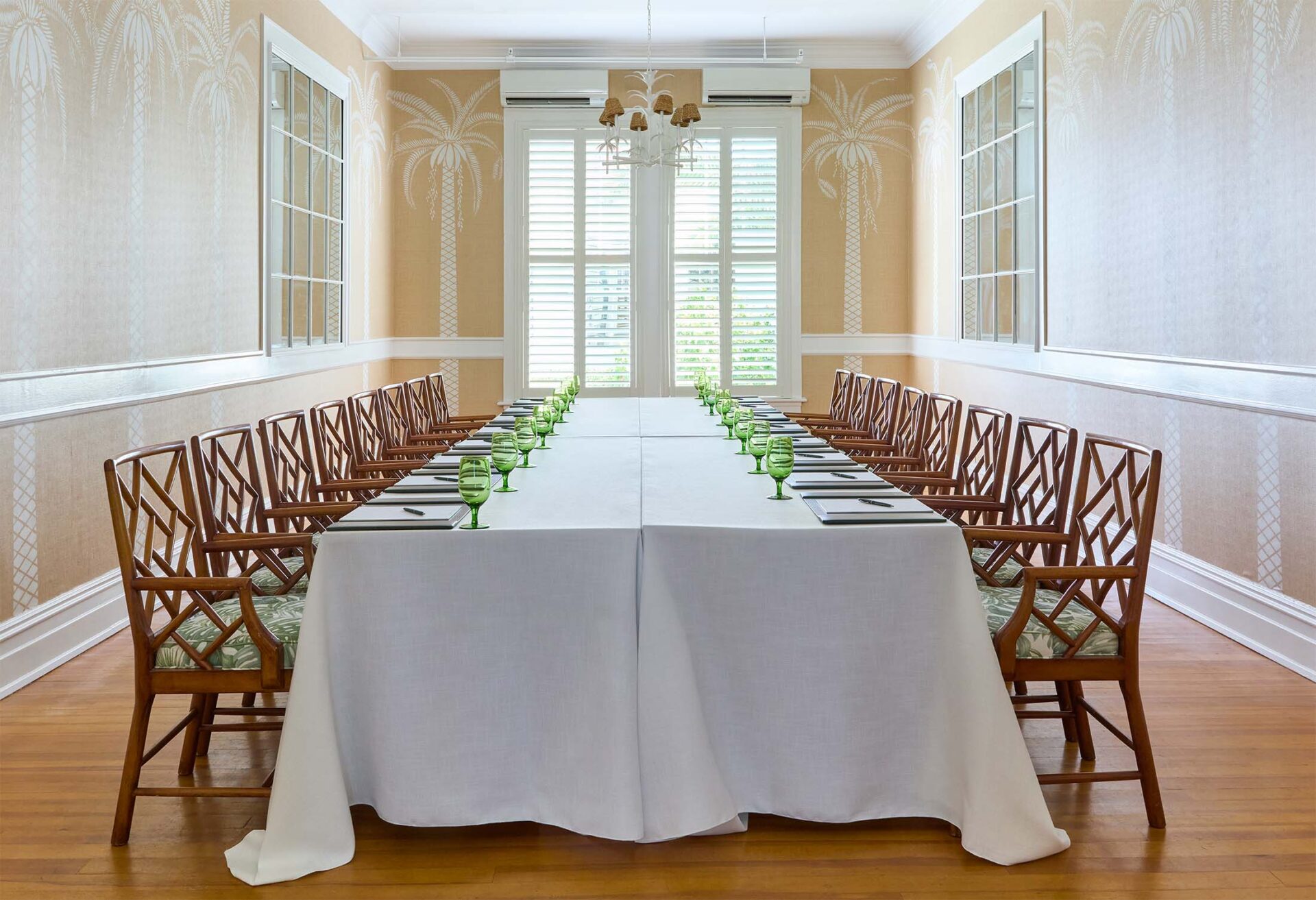 A large conference table flanked with sixteen handsome wooden chairs