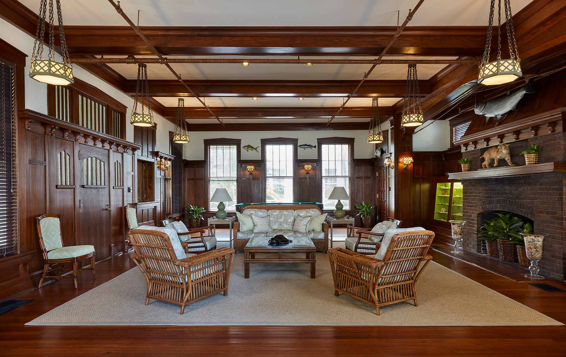 Lush mahogany paneling and a brick hearth surround a handsome seating area