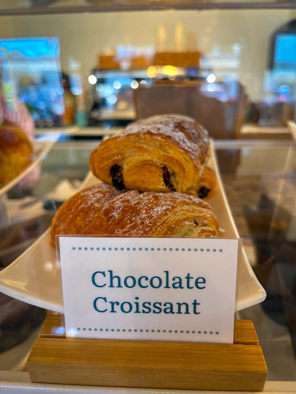 Close-up of a stack of chocolate croissants on a slender porcelain plate